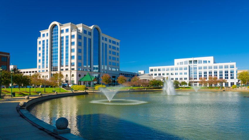 Newport News office buildings with multiple fountains and a lake.