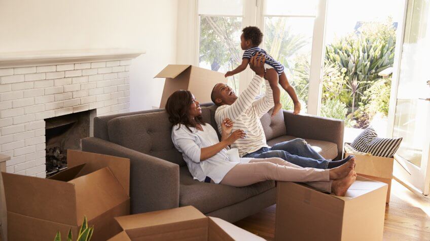 Parents Take A Break On Sofa With Son On Moving Day.