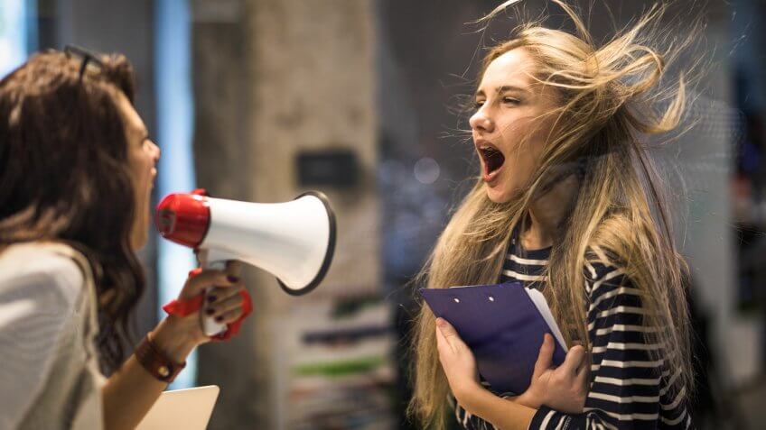 Rude female leader yelling at her coworker through megaphone.