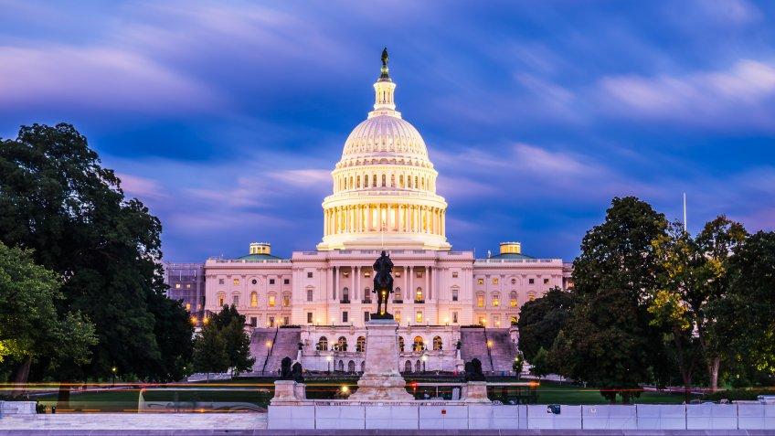 The United States Capitol building at twilight wirth reflection in water.