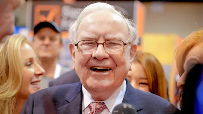 Berkshire Hathaway Chairman and CEO Warren Buffett laughs while touring the exhibit floor at the CenturyLink Center in Omaha, Neb