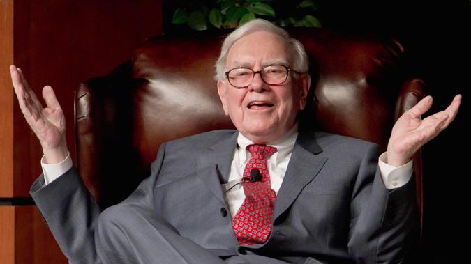 Warren Buffet makes hand gesture on chair