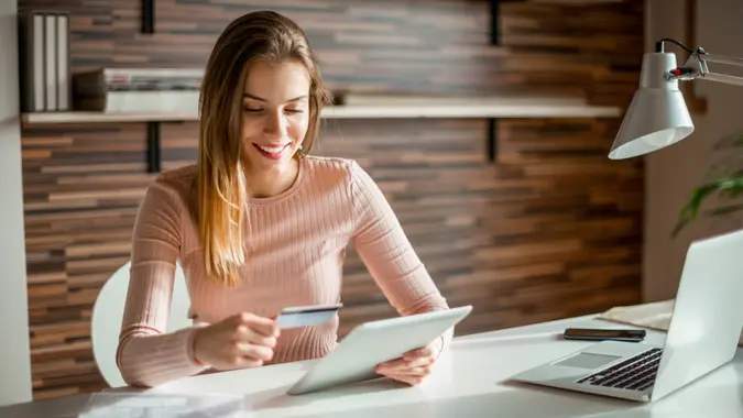 woman holding a credit card and tablet