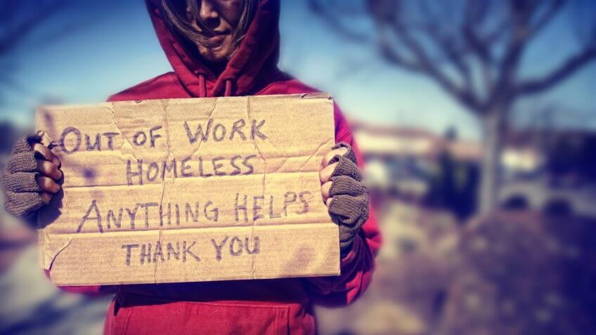 a homeless person with a sign.