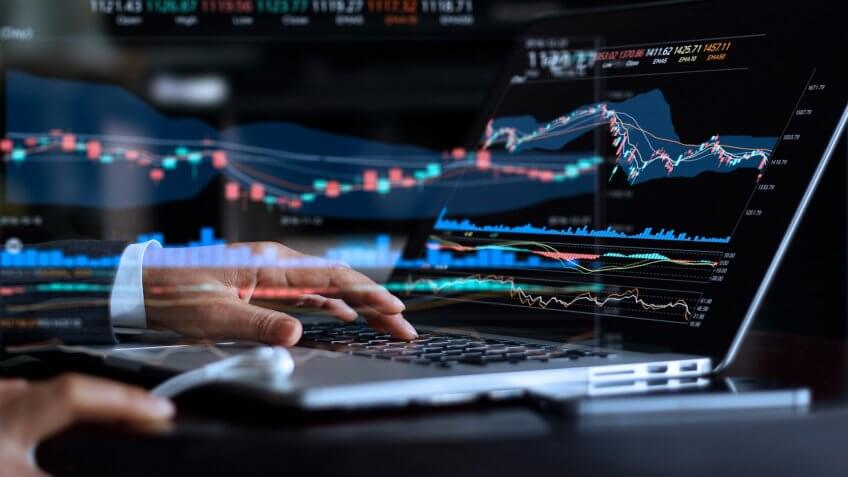 Businessman with statistic graph of stock market financial indices analysis on laptop screen, finance data and technology concept.