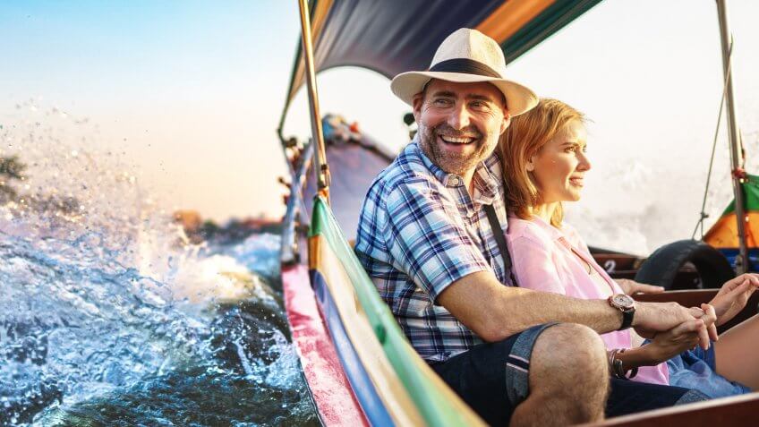 Middle-aged man and his companion handsome blond lady on a boat ride in Bangkok.