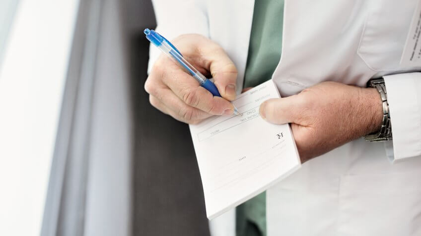 Close up of a doctor filling out a prescription.