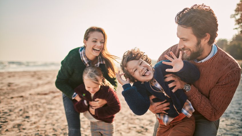 Close up of a young family enjoying time on a beach.