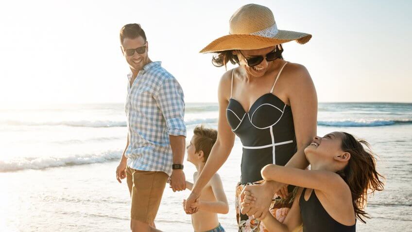 Shot of a family of four spending the day at the beach.