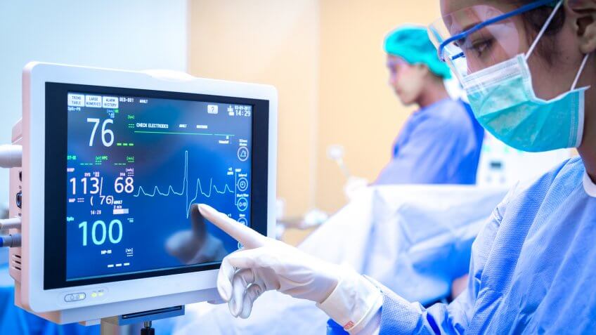 Female surgeon using monitor in operating room.