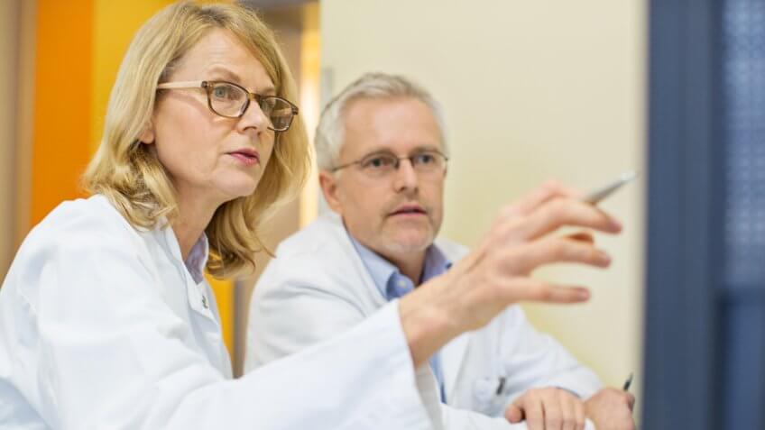 Doctors looking at computer on desk.