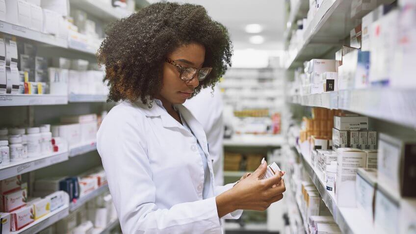 Shot of a focused young female pharmacist walking around and doing stock inside of a pharmacy.