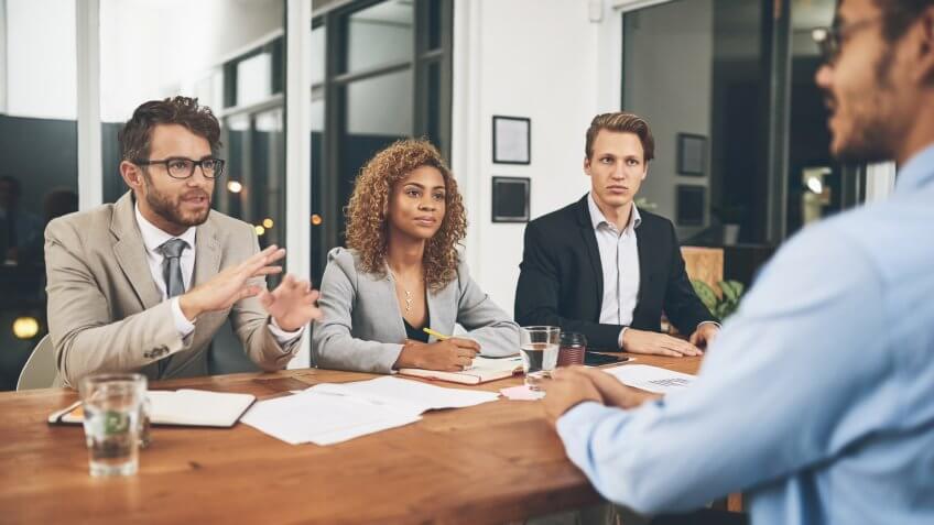 Shot of a group of businesspeople interviewing a candidate in an office.
