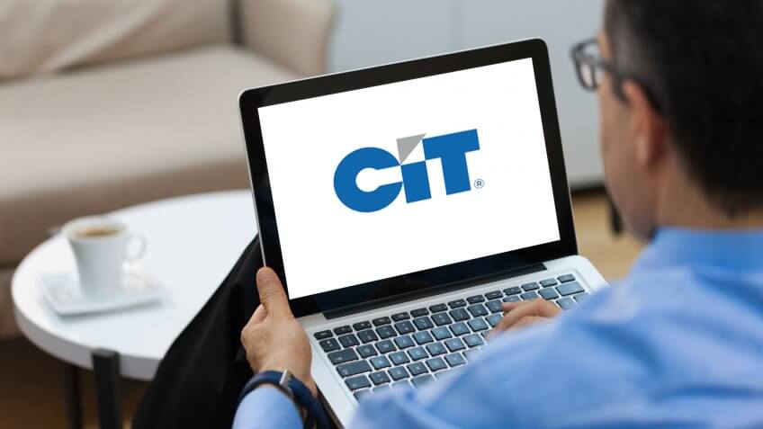 Businessman working on laptop on CIT Bank website.