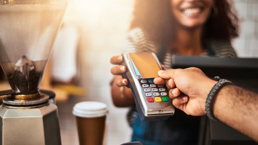 Closeup shot of a customer making a credit card payment in a cafe.