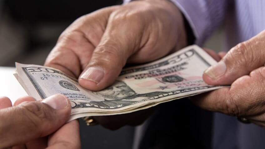 Cashier giving US cash money to a client.