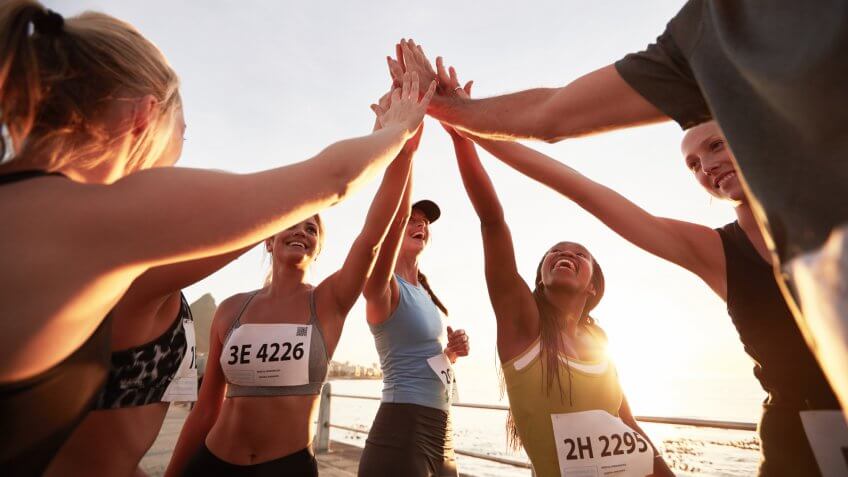 Runners high fiving each other after a good training session.