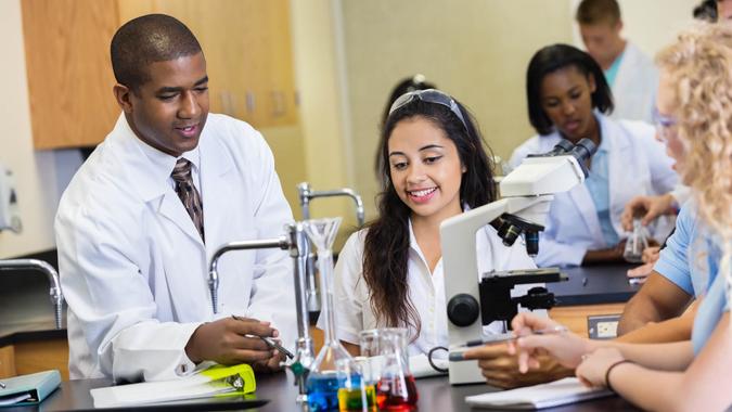 African American mid adult man is teacher in modern science lab classroomm.