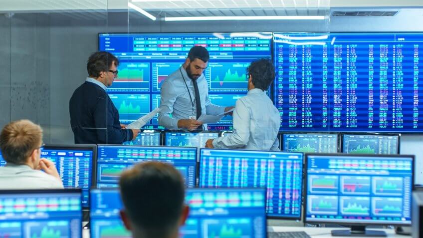 Three Experienced Stock Traders Talking Business, Consulting Documents and Argue About Data.