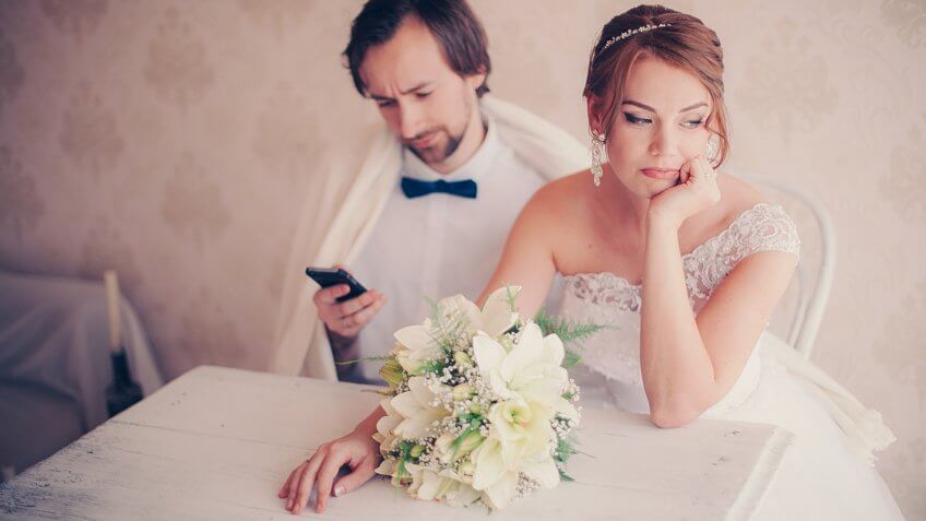 the bride upset the groom is distracted by the phone during a wedding photo session, careless couple.