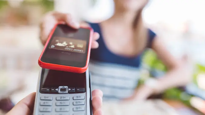Young woman paying with mobile  phone.