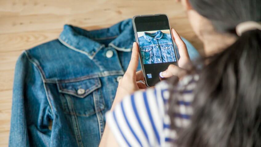 woman taking photo of denim jacket in a store