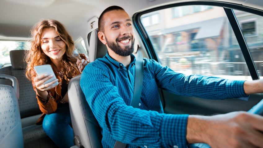 a rideshare driver driving a passenger with a smartphone