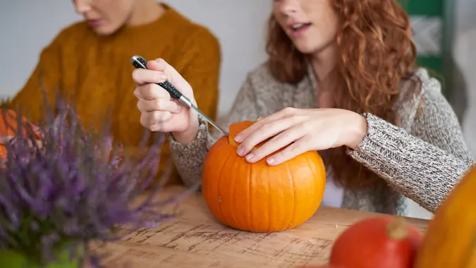 Woman's hands preparing decorations for Halloween.