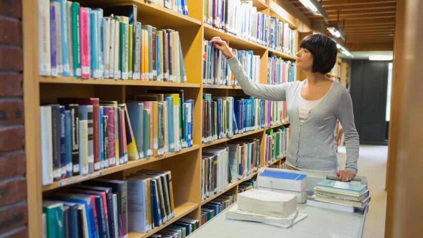 Librarian returning books to shelf.