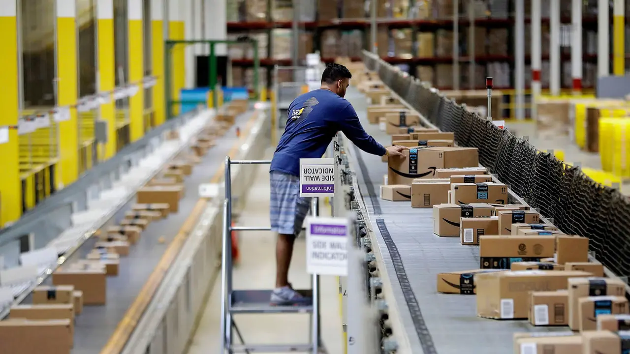 Mandatory Credit: Photo by AP/REX/Shutterstock (8979717e)An Amazon employee makes sure a box riding on a belt is not sticking out at the Amazon Fulfillment center in Robbinsville Township, N.