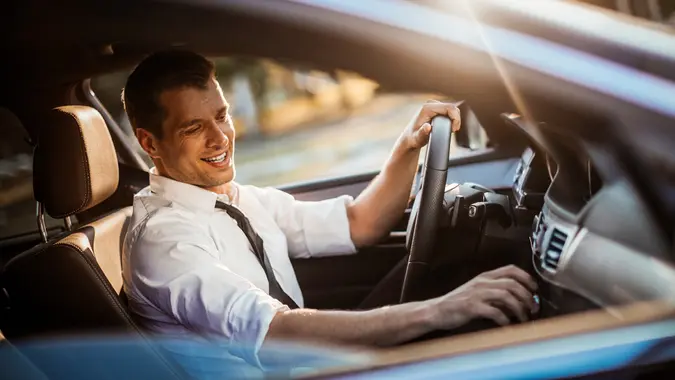 Close up photo of a businessman driving a car.
