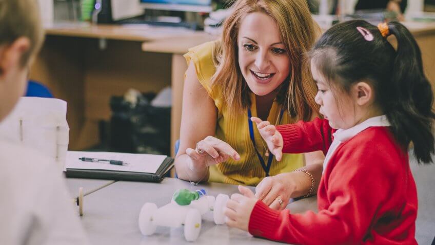 female teacher working with girl student