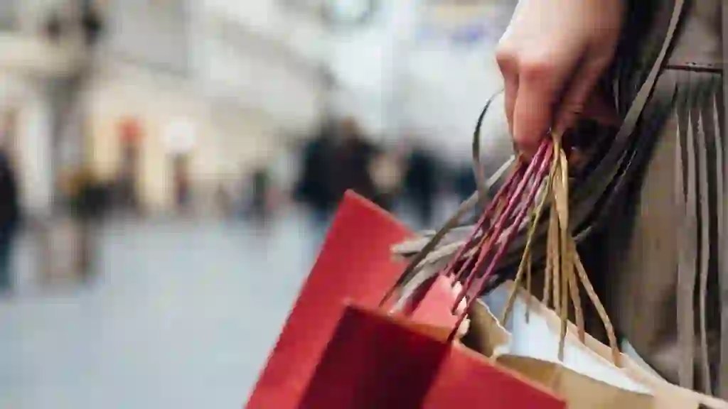 Closeup of woman holding shopping bags on the street with copy space.