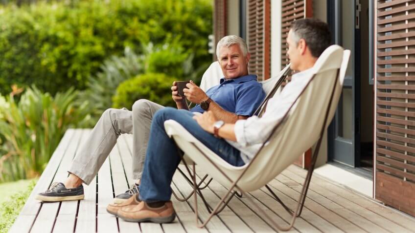 Full length of mature male friends spending leisure time at yard.