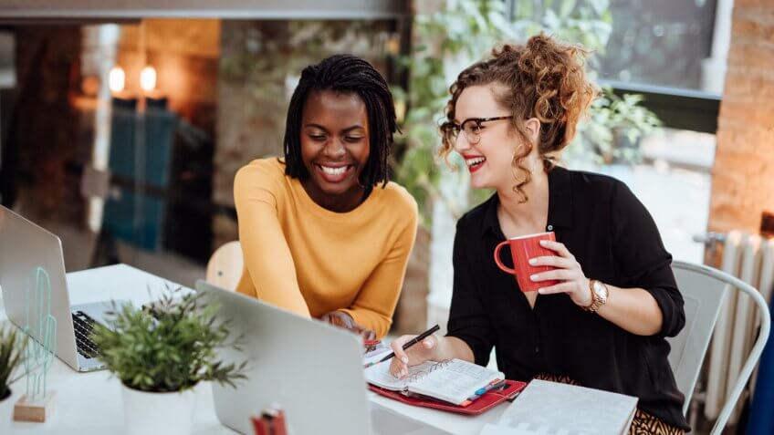 Two Businesswomen Working On Computer In Office.