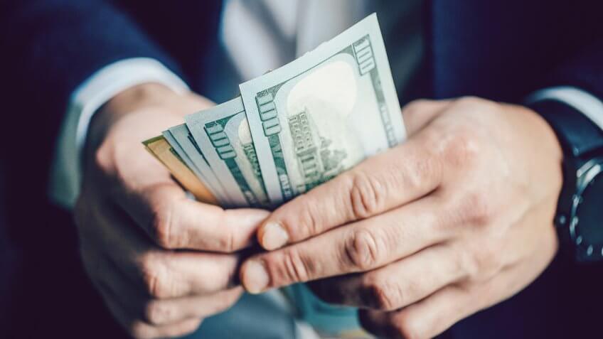 Close up, of male hands counting dollar bills, filtered image, business man working financial adviser and counting money banknotes.