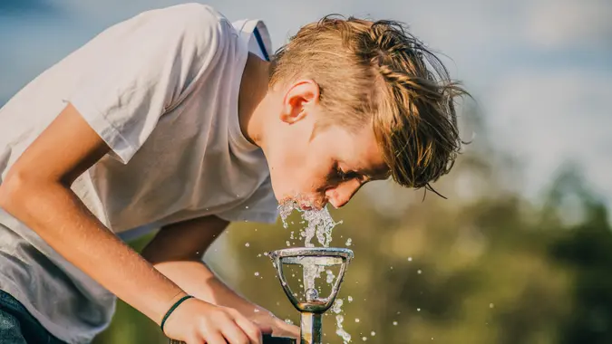 Young boy drinking from a water fountain in a park in Melbourne, Australia.