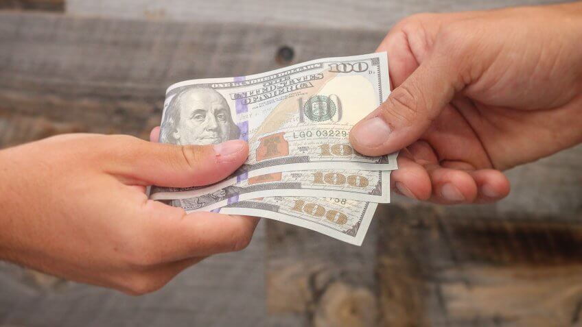 hands exchanging USD money
