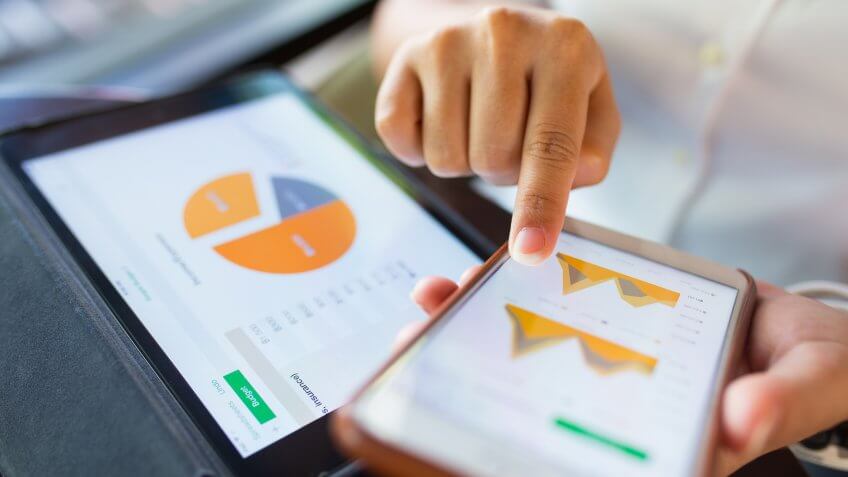 Businesswoman check data in smartphone and tablet.