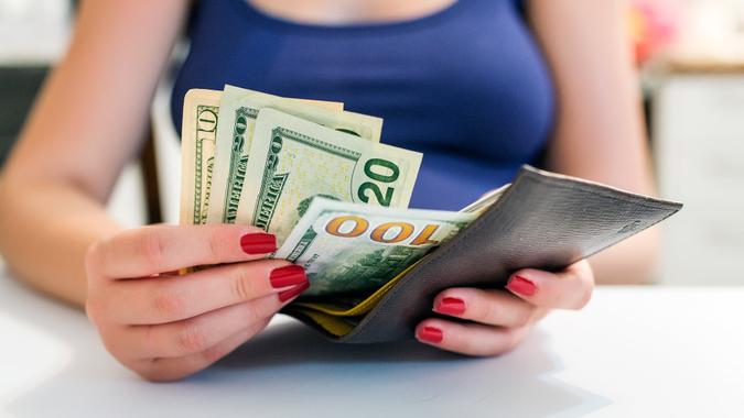 people, business, finances and money concept - close up of businesswoman hands holding open wallet with dollar cash.
