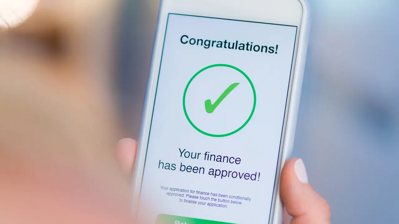 Mortgage Loan approval on mobile phone in a house.