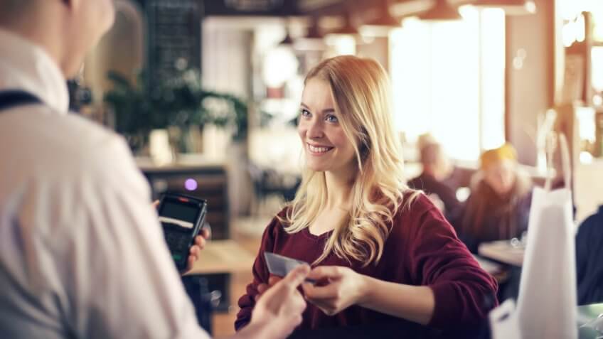 Blonde girl paying with credit card.