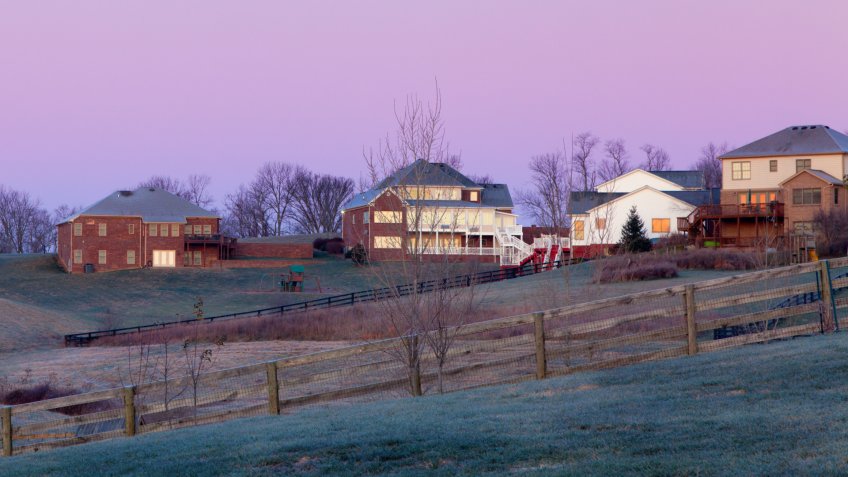 Moon setting over a suburban residential neighborhood.