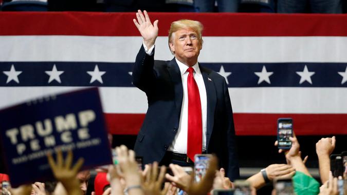 President Donald Trump waves hand at rally