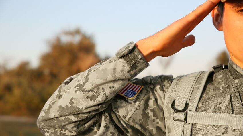Soldier in camouflage taking salute outdoors