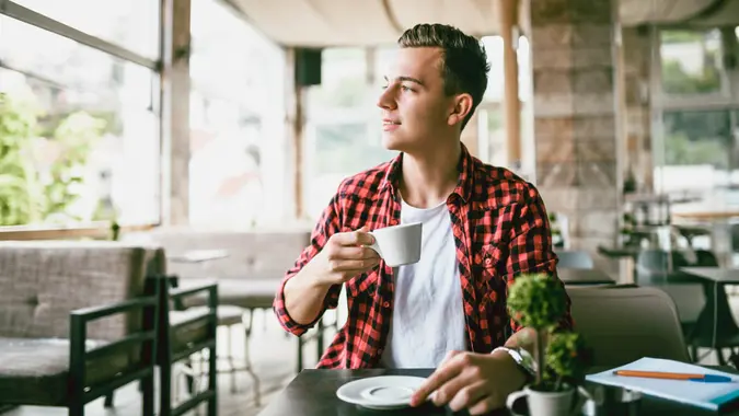 Young Male In Hipster Shirt Enjoys A Smell Of Good Morning Coffee.