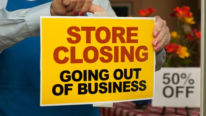 Store Closing sign being placed on a shop window.