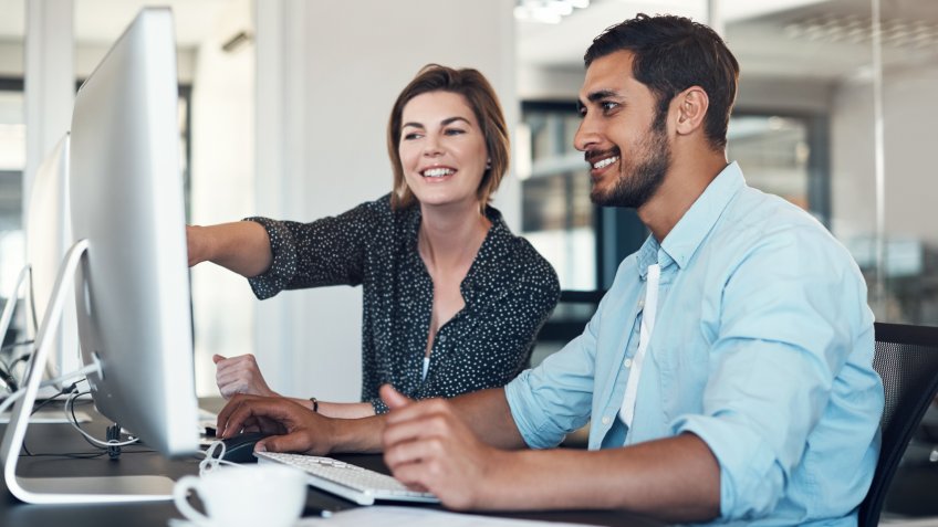 Shot of a businessman and businesswoman using a computer together in a modern office.