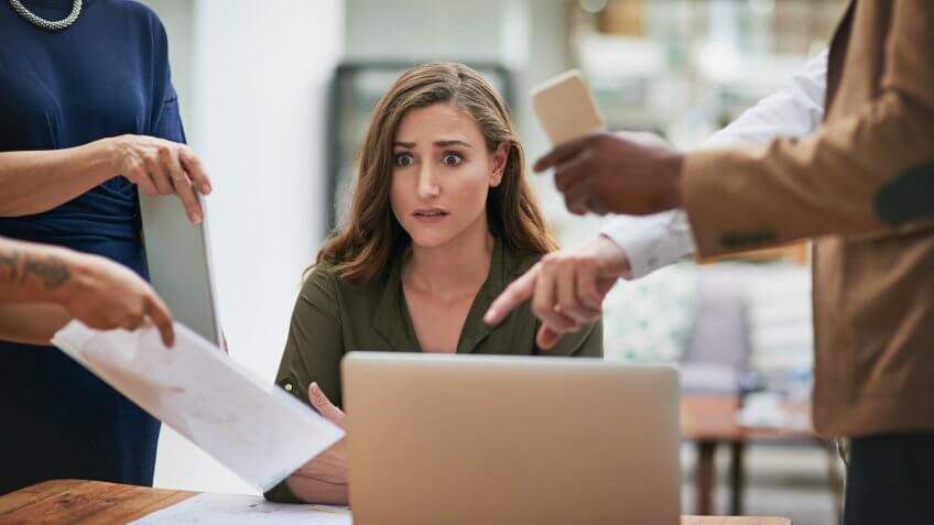 Shot of a young businesswoman looking anxious in a demanding office environment.