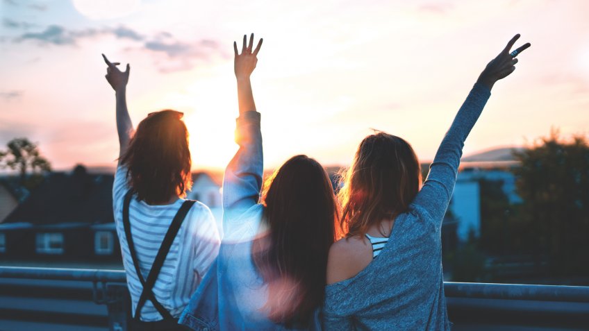 girls having fun on rooftop at sunset